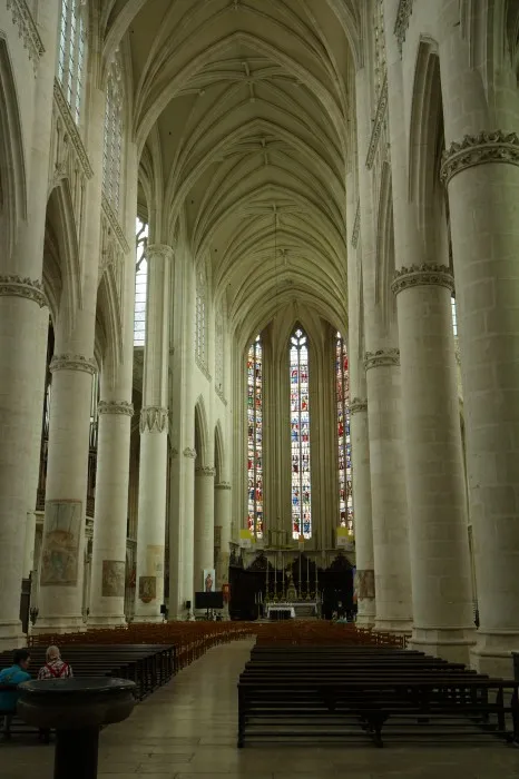 Ein weißes Kirchenschiff streckt sich in den Hintergrund. Hinten sind schmale hohe Fenster zu sehen. Das Schiff ist etwas gekrümmt.