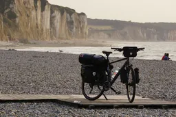 Mein Fahrrad am Strand vor einigen Kreidefelsen. Das Rad hat 2 Satteltaschen, einen Packsack, 2 Taschen am Vorderrad und eine Lenkertasche.