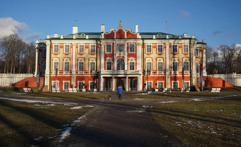 Einzeln stehenedes Schloss mit roter und gelber Fassed und grünem Dach.