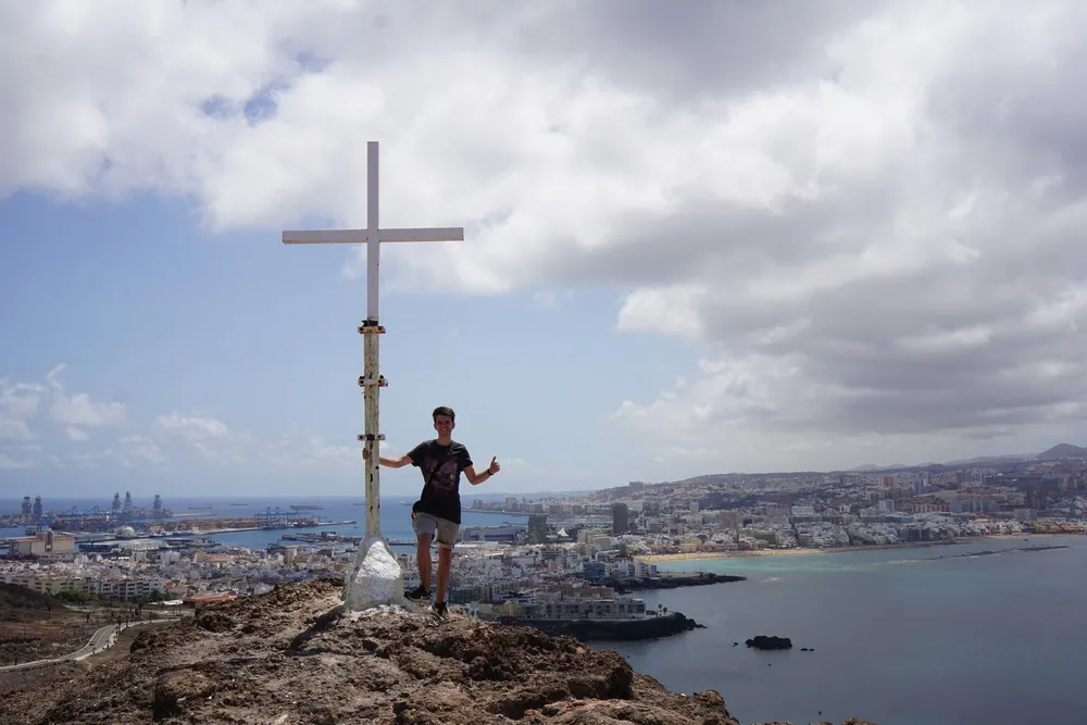 Ich stehe am Gipfelkreuz vor einer atemberaubenden Aussicht auf die Stand und ihre Strände