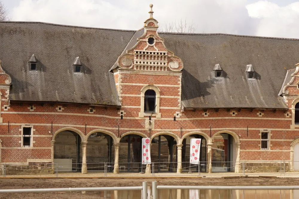 Etwas schlichteres Gebäude aus Ziegelsteinen mit schiefem Bögen am Eingang und einem Giebel in der Mitte.