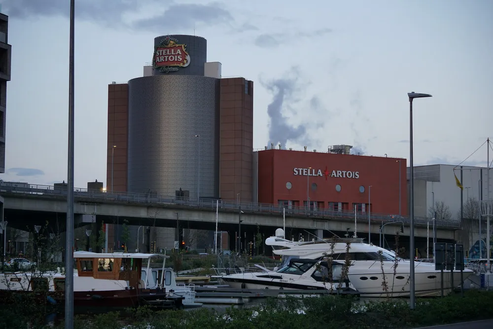 Im Hintergrund ein großes, rundes, modernes Gebäude mit dem Logo von Stella Artois. Im Vordergrund einige Boote.