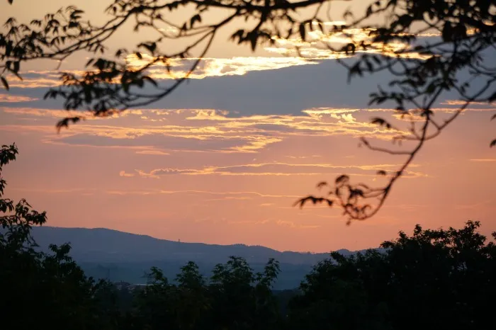 Die Abendsonne versteckt sich hinter einer einzelnen Wolke und taucht die Harzer Gebirgslandschaft in ein wunderschönes Abendrot.