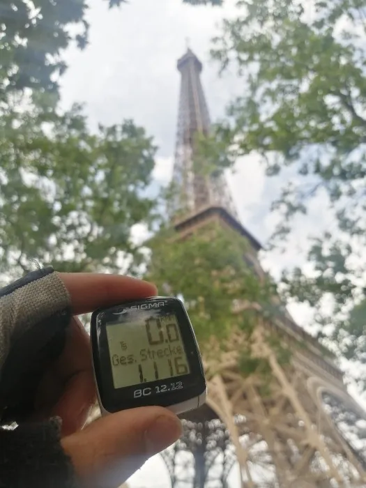 Tach mit der Anzeige "1116 Gesamtstrecke" vor dem Eiffelturm.