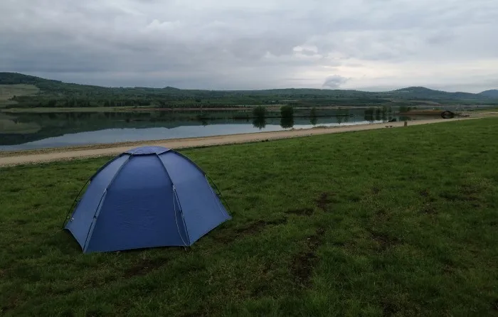 Unser Zelt auf dem Rasen des Campingplatzes mit Blick auf den See.