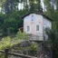 Ein kleines, altes Zöllner Haus an einer alten Schleuse an einem Kanal in Frankreich. Es steht auf einer einem kleinen Fels umgeben von Wald.