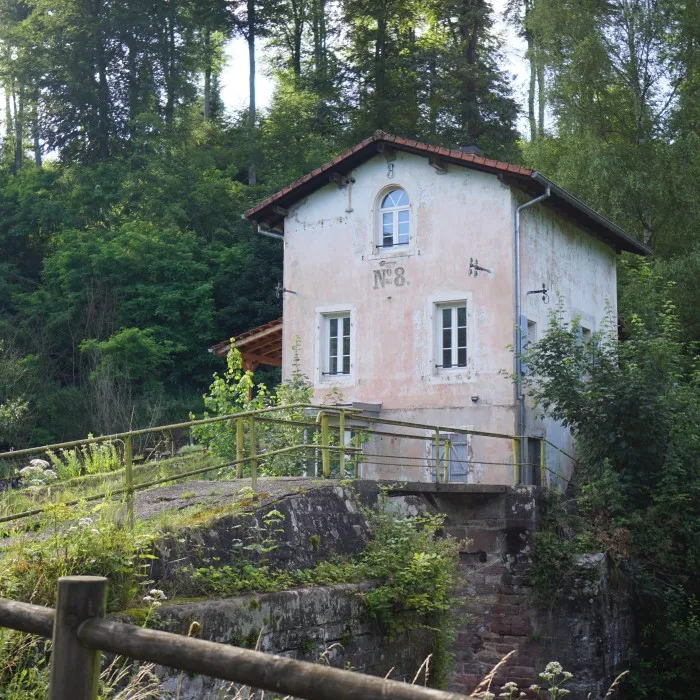 Ein kleines, altes Zöllner Haus an einer alten Schleuse an einem Kanal in Frankreich. Es steht auf einer einem kleinen Fels umgeben von Wald.